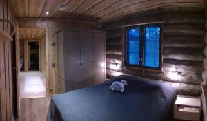 a teddy bear sitting on a bed in a room at Revontuli Cottage in Kolari