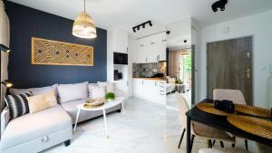 a living room and kitchen with a couch and a table at HELLO Apartamenty - Pohulanka w sercu Karpacza in Karpacz