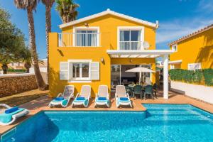 una villa con piscina frente a una casa en Villa Benjamin by Villa Plus, en Sa Caleta