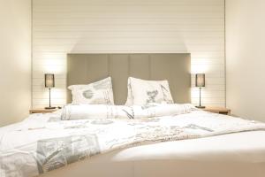 グリンデルワルトにあるKehr Apartmentのベッドルーム(白い大型ベッド、ランプ2つ付)