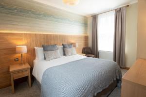 a bedroom with a large bed and a window at Fistral Beach Hotel and Spa - Adults Only in Newquay