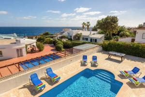 uma vista aérea de uma piscina com cadeiras e do oceano em Villa Claudia by Villa Plus em S'Algar