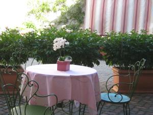 un tavolo con una tovaglia rosa e sedie con piante di B&B Ristorante del Monte a Colleretto Giacosa