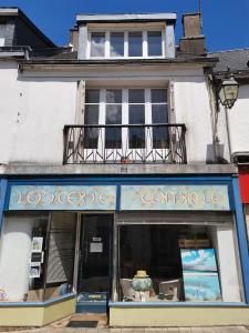 a store front of a building with a balcony at Mignon appartement sous les toits in Guéméné-sur-Scorff