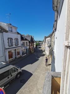 a person walking down a street with a car at Mignon appartement sous les toits in Guéméné-sur-Scorff