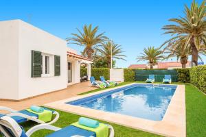 una piscina en un patio con sillas y una casa en Villa Beltran by Villa Plus, en S'Algar