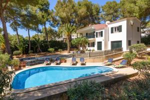 a villa with a swimming pool in front of a house at Villa Alessandra by Villa Plus in Santo Tomás