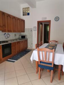 una cucina con tavolo e sedie e una cucina con lavandino di Radici Blu intero alloggio a Siderno Marina