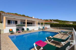 a swimming pool with chairs and a house at Villa Santo Tomas by Villa Plus in Santo Tomás