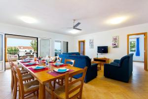 Un comedor y una sala de estar con mesa y sillas. en Villa Santo Tomas by Villa Plus, en Santo Tomás
