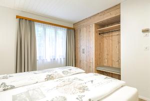 a bedroom with a bed and a window at Lauberhorn Apartment in Grindelwald