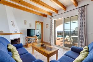 een woonkamer met een blauwe bank en een tafel bij Villa Laurel by Villa Plus in Alaior