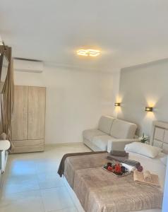 a white bedroom with a bed and a couch at petros house in Sarti