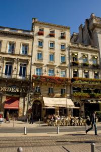 a man walking past a building in a city at Hotel des 4 Soeurs in Bordeaux