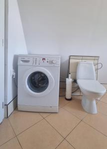 - un lave-linge dans la salle de bains pourvue de toilettes dans l'établissement Apartment na poddaszu, à Augustów