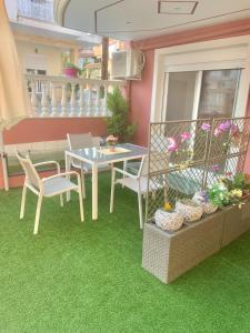 a table and chairs on a balcony with green grass at petros house in Sarti