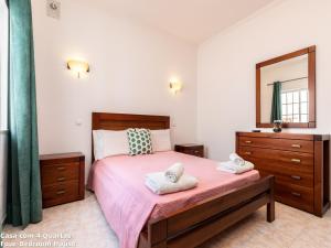 een slaapkamer met een bed met roze lakens en een spiegel bij Akisol Albufeira Sun in Albufeira