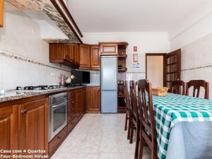 a kitchen with a table and a refrigerator at Akisol Albufeira Sun in Albufeira