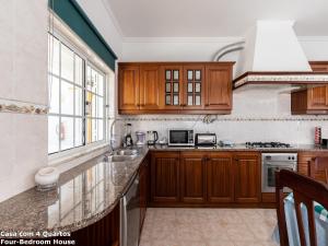 a kitchen with wooden cabinets and a large window at Akisol Albufeira Sun in Albufeira