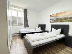 une chambre avec deux lits et une fenêtre dans l'établissement SAD190 - Zentrale Moderne Monteurwohnungen, à Schwandorf in Bayern