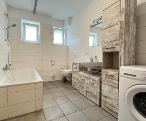 W łazience znajduje się toaleta z umywalką i pralka. w obiekcie SAD190 - Zentrale Moderne Monteurwohnungen w mieście Schwandorf