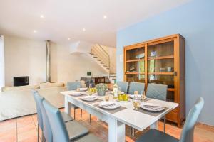 una sala da pranzo con tavolo bianco e sedie blu di Villa Serafina by Villa Plus a Son Parc