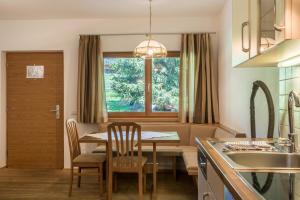 cocina y comedor con mesa y ventana en Ferienparadies Sabina Puflatsch, en Alpe di Siusi