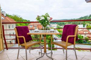 una mesa y sillas en un balcón con vistas en Penzion Sinfonietta, en Luhačovice