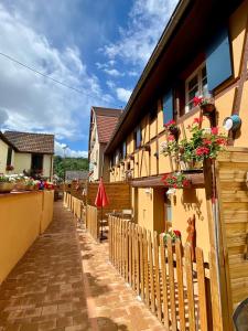 a fence next to a building with flowers on it at Coeur d'Alsace Colmar Vignobles Ouest avec terrasses in Wintzenheim