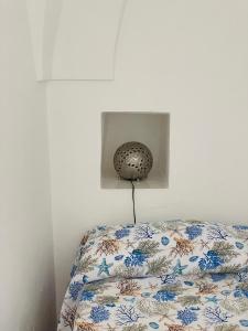 Bett mit einer Bettdecke in einem weißen Zimmer in der Unterkunft Studio Alli in Pantelleria