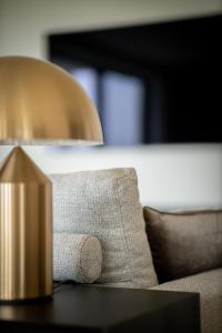 a lamp sitting on a table next to a couch at Luxurious design appartement, 2 bedroom 4 person in Cadzand