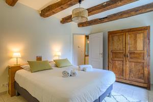 um quarto com uma grande cama branca e 2 toalhas em KER CASE A NOU - Belle Longère familiale à la campagne à 10 minutes de Vannes em Monterblanc