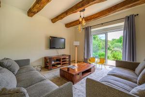 a living room with a couch and a tv at KER CASE A NOU - Belle Longère familiale à la campagne à 10 minutes de Vannes in Monterblanc