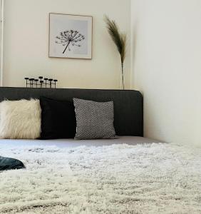 a bed with a black headboard and a white blanket at Deich Quartier 9.2 in Dorum Neufeld