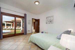 sypialnia z łóżkiem i patio z basenem w obiekcie Villa Duna Mar by Villa Plus w Corralejo +10 zdjęć