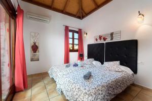 sypialnia z dużym łóżkiem z czarnym zagłówkiem w obiekcie Villa Duna Mar by Villa Plus w Corralejo