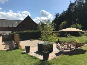 a garden with a table and chairs and an umbrella at The Cheese Room, self-contained cosy retreat in the Quantock Hills in Bridgwater