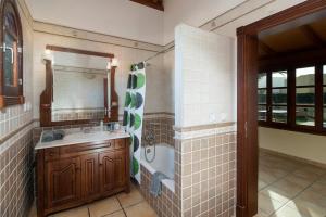 łazienka z umywalką i prysznicem oraz lustrem w obiekcie Villa Duna Mar by Villa Plus w Corralejo