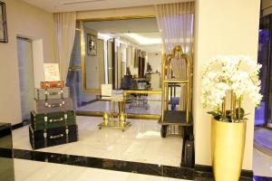 The George Hotel by Saffron, Dubai Creek في دبي: غرفة خلع الملابس مع مرآة و إناء من الزهور