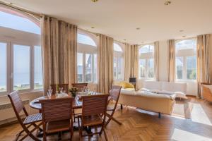 salon z kanapą, stołem i krzesłami w obiekcie L'Ambassadeur - Magnifique appartement dans l'ancien hôtel Ar Vro w mieście Saint-Cast-le-Guildo