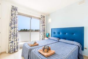 sypialnia z niebieskim łóżkiem i oknem w obiekcie Villa Jenny by Villa Plus w Corralejo