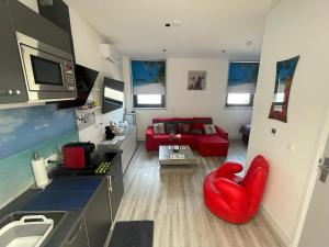 a living room with a red chair and a red couch at Scottish Thistle in Zandvoort