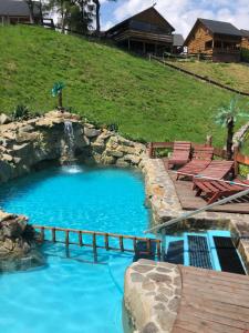 duży basen z drewnianym tarasem i zjeżdżalnią wodną w obiekcie Agroturystyka Paradiso w mieście Ropa