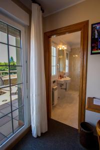 a bathroom with a glass door leading to a bathroom with a sink at Hotel San Jorge in Nueva de Llanes