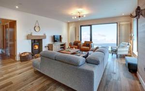 a living room with a large couch and a fireplace at 5 Bedroom Cottage - Llyn Peninsula in Pistyll