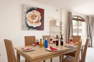 un comedor con una mesa de madera con copas de vino en Villa Nanda by Villa Plus en Corralejo