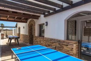 un patio con mesa de ping pong frente a una casa en Villa Nanda by Villa Plus en Corralejo