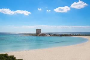 einen Strand mit einem Leuchtturm inmitten des Ozeans in der Unterkunft Residence Jolly Mare in Torre Lapillo