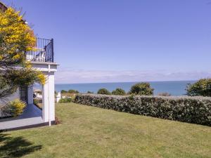 a house with a garden and the ocean in the background at Pentire House in Deal
