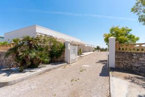 ein Gebäude mit einer Steinmauer und einem Zaun in der Unterkunft Residence Jolly Mare in Torre Lapillo + 11 Fotos